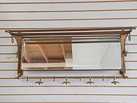 Front view showing full brass rack with mirror and hooks