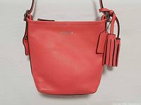 Front view of coral Coach crossbody showing overall condition and branding