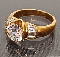 Side view showing round center stone and baguette accents