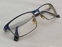 Front angle view showing rectangular gunmetal frame with blue accent and clear lenses