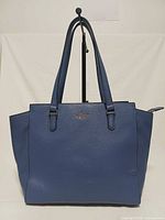 Front view of blue pebbled leather Kate Spade tote showing logo and overall condition