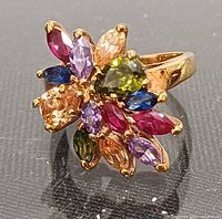 Front view of gold tone ring with multicolor rhinestone floral cluster