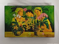 Closed box top showing mosaic stone artwork of three women with orchids