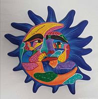Front view of ceramic sun and moon plaque showing full design and colours