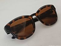 Front angled view showing tortoiseshell frame and brown lenses