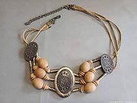 Full view of belt showing metal medallions, wood beads and cord construction