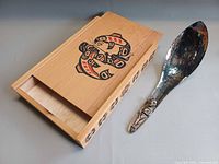 Cedar box with slide lid open and silverplate spoon beside it