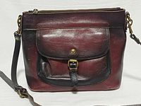 Front view showing flap pocket, buckle, color gradient and hardware