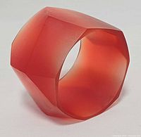 Angled view of red faceted frosted lucite bangle bracelet