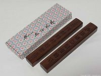 Two rosewood paperweights with patterned box