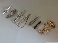 Full lineup of seven jewellery pieces on grey background