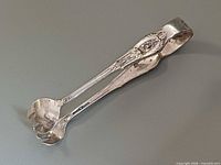 Closed view of ornate Wallace sterling sugar tongs showing pattern and claw tips