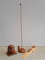 Group shot of Buddha figurine, kinetic woodpecker toy and cheese-shaped door stop with mice