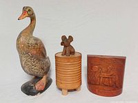 All three wooden items grouped: duck, music box with dog topper, relief carving