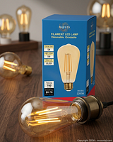 Boxed Bright Or filament LED bulb beside loose bulb on table