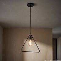Single triangular black metal pendant hanging from ceiling