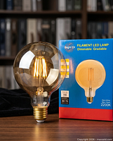 Amber LED globe bulb beside retail box
