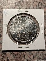 Obverse of coin in holder showing ferry image and legends