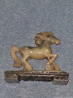Front view of serpentine horse figurine on stone base
