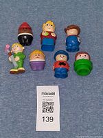 Front view of all seven plastic figures on blue surface