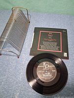 Record A-side label, picture sleeve back and metal rack overview