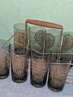 Front view of eight smoky gray tumblers in metal carrier