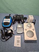 Group shot showing all electronics including Tivoli radio, webcam, charger, controller, HMDX speaker, cables