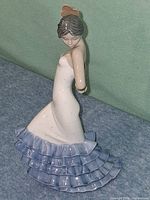 Front angled view of figurine showing pose, dress and colors