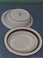Two oval serving bowls, one inverted showing mark, one upright showing interior design