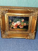 Front view of framed oil painting showing floral subject and gilded frame