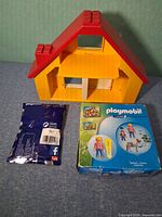Front view of dollhouse, boxed set and sealed blind bag