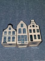 Front view of three Delft house bottles showing facades and blue detailing