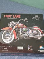 Front of sealed puzzle box showing motorcycle artwork, title, piece count