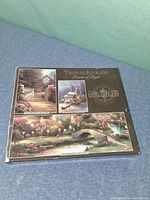 Front of Thomas Kinkade multi-puzzle box