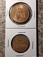 Front of both coins in flips showing Britannia 1d and feathers 2p reverses