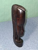 Oblique view of carved wooden bust showing profile and top hair detail