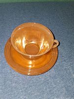 cup resting on saucer showing overall iridescent finish