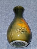 Full view showing vase front with orange flower against olive glaze