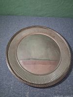 Front view showing fluted inner border and braided rim of silver-tone charger