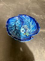 Top view of blue leaf-shaped ceramic dish with grape relief