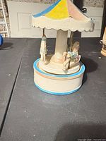 angled view of ceramic carousel music box on table