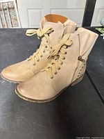 Boots angled left showing laces, toe, side zipper, overall condition