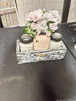 front view of centerpiece showing all three jars in tray with flowers