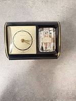 Front view of clock showing dial and animated figurine window