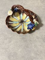 Full view of ceramic basket showing scalloped interior and twisted handle