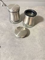 Both spice jars shown with one lid off displaying black gasket