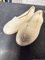 Full view of both espadrille flats angled to show crochet toe and jute wrap