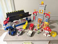Group shot of castle, truck, vehicles, figures, plush and hat