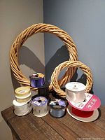 Lot overview with two wicker wreaths and assorted ribbon spools on table