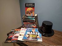 Group shot of all books stacked and spread, plus top hat